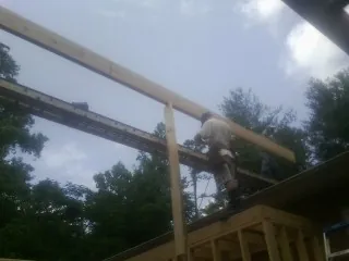 Carpenter setting a ridge beam over a new addition frame — Ice Dam Removal by Roofing Brothers in Centerburg