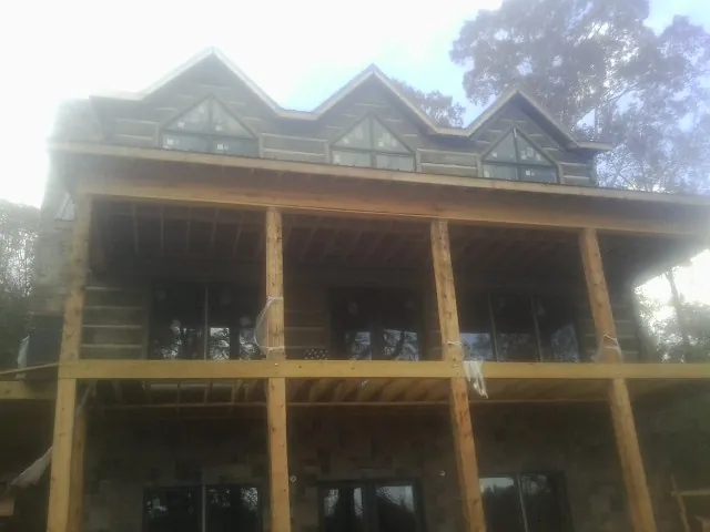 Dormers and porch framing on a large log home under construction — Roof Coating work by our crew in Centerburg