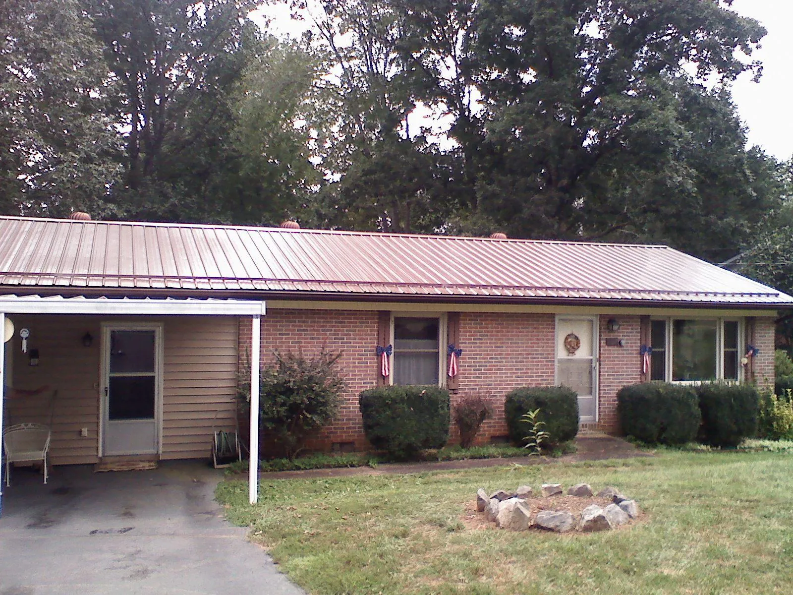 Bronze metal roof and carport on a brick ranch home — Roof Repair work by our crew in Centerburg